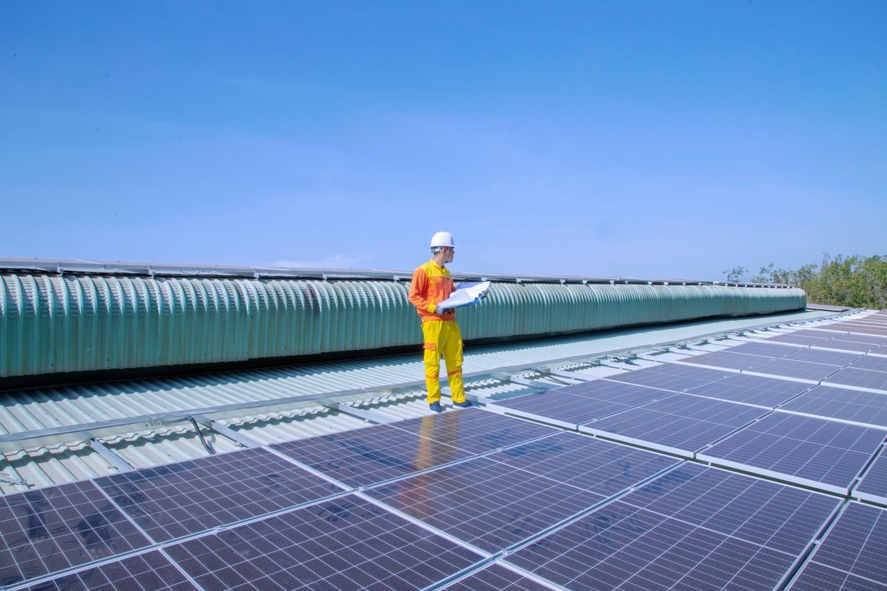 Crafting Captivating Headlines: Your awesome post title goes here Technician examining solar panels on a rooftop, emphasizing renewable energy.